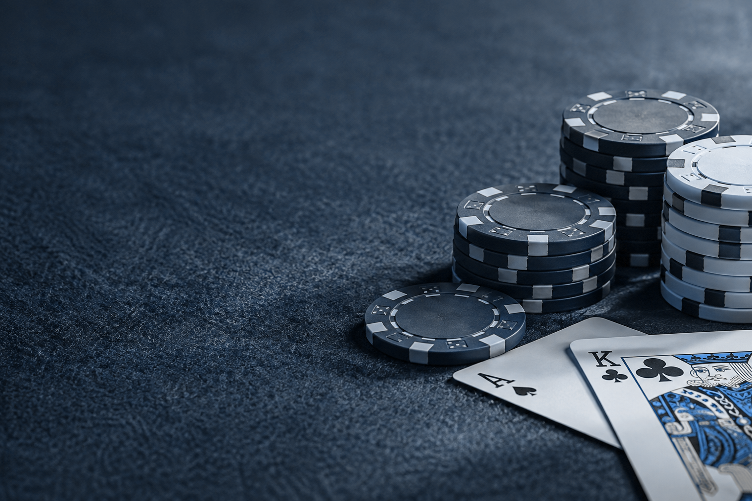深いネイビーのテーブルに並ぶカードとポーカーチップ